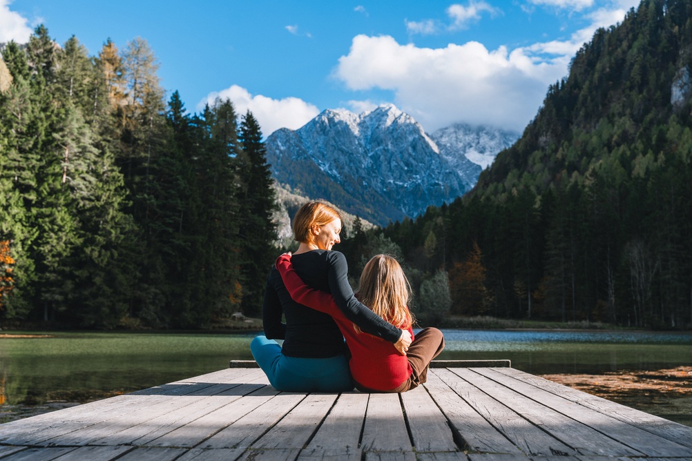 Mother,And,Child,Sitting,On,A,Pier,By,A,Mountain